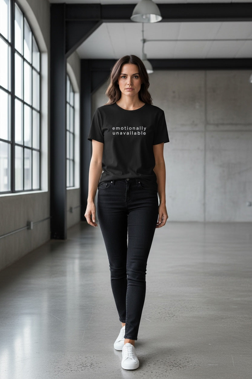 Woman wearing a black emotionally unavailable t-shirt with text in an industrial setting
